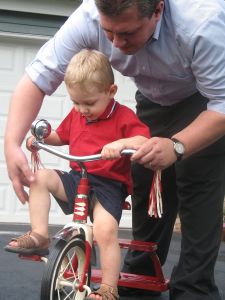 Boy learning to ride a tricycle