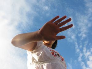 Woman with hand out, blocking face, like saying "Don't look at me."