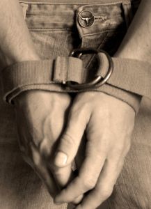 Man's hands bound by a strap