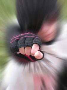 Blurred photograph of person punching toward viewer, only fist is in focus