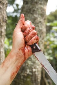 Bloody hand holding large knife