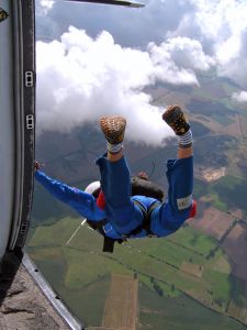 View from inside plane of a skydiver stepping out the door