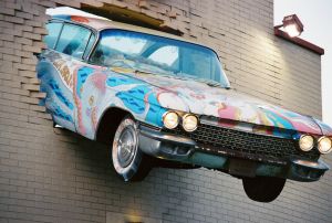 Cadillac bursting out of a wall