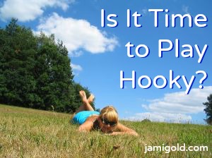 Woman lying down in a meadow with text: Is It Time to Play Hooky?