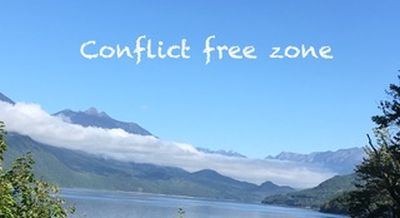 Peaceful lake and mountain landscape with text: Conflict free zone